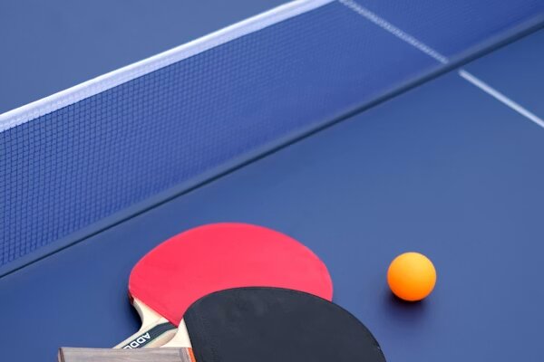 Palas y pelota de tenis de mesa sobre la mesa de juego